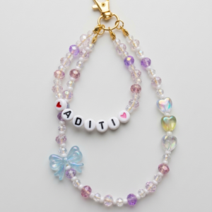 Custom name bag charm with double strand pastel crystal beads, white letter beads, iridescent bow and heart charms on a gold lobster clasp