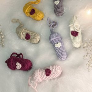 Handmade crochet lip balm holder keychains in multiple colours including yellow, grey, sage, lavender, burgundy, pink and cream each with a small heart detail