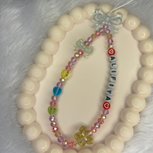 Personalised multicolour phone charm with rainbow crystal beads, colourful heart charms, bow charm and custom name letter beads on a white cord