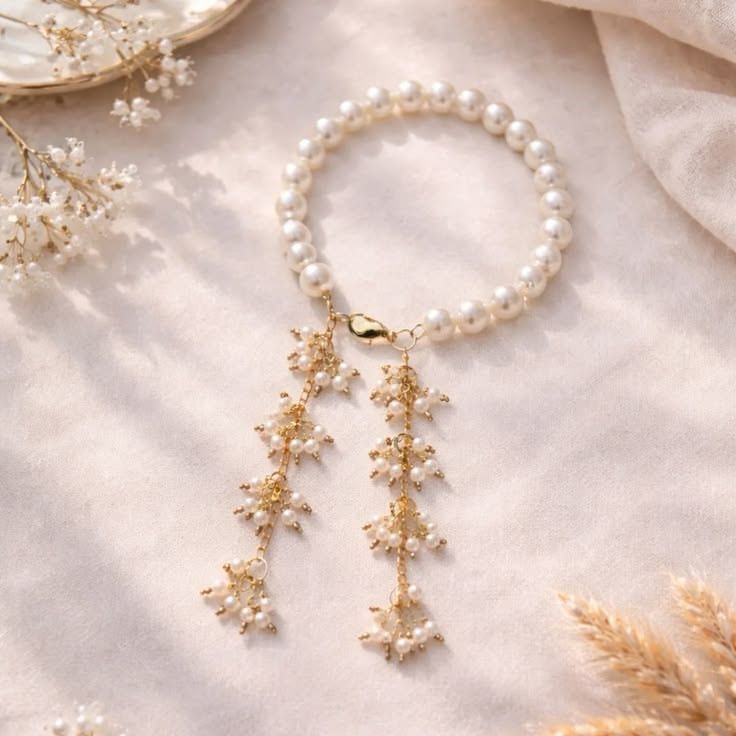 Pearl bracelet with double gold chain tassel drop featuring tiny seed pearl clusters on gold wire