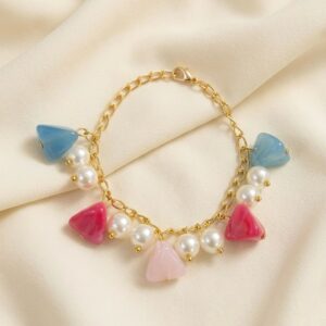 Gold chain bracelet with colourful triangle shaped charms in blue, pink and magenta paired with white pearl clusters and gold bead accents