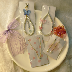 6-piece personalised Raksha Bandhan gift hamper with pearl necklace, pearl earrings, personalised bag charm, phone charm, bow and claw clip