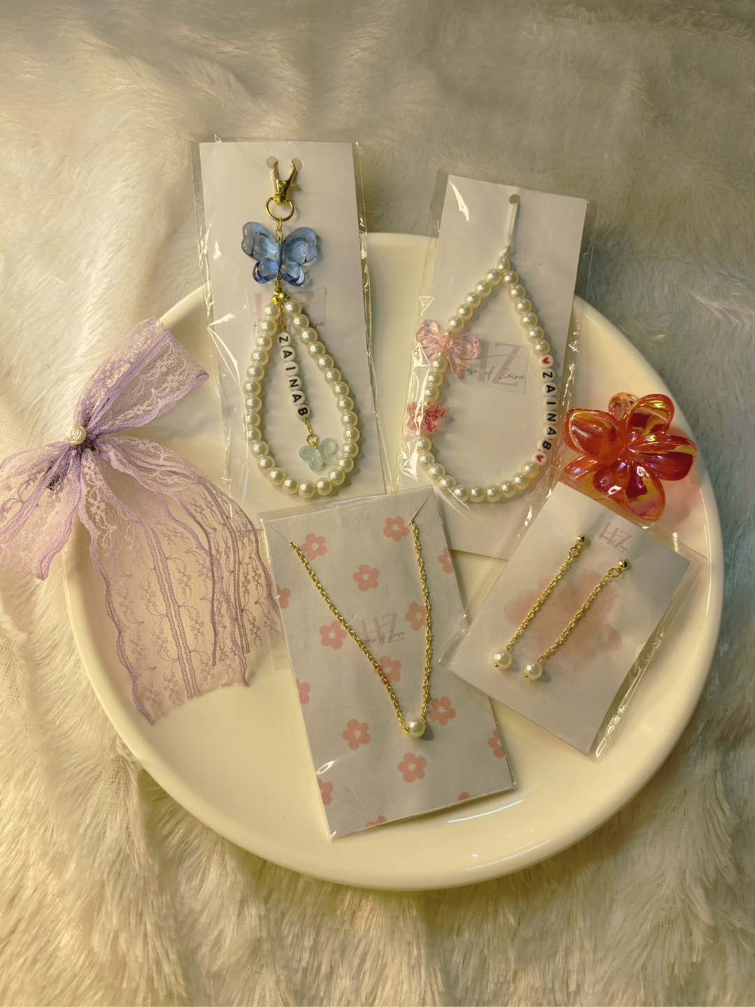 6-piece personalised Raksha Bandhan gift hamper with pearl necklace, pearl earrings, personalised bag charm, phone charm, bow and claw clip