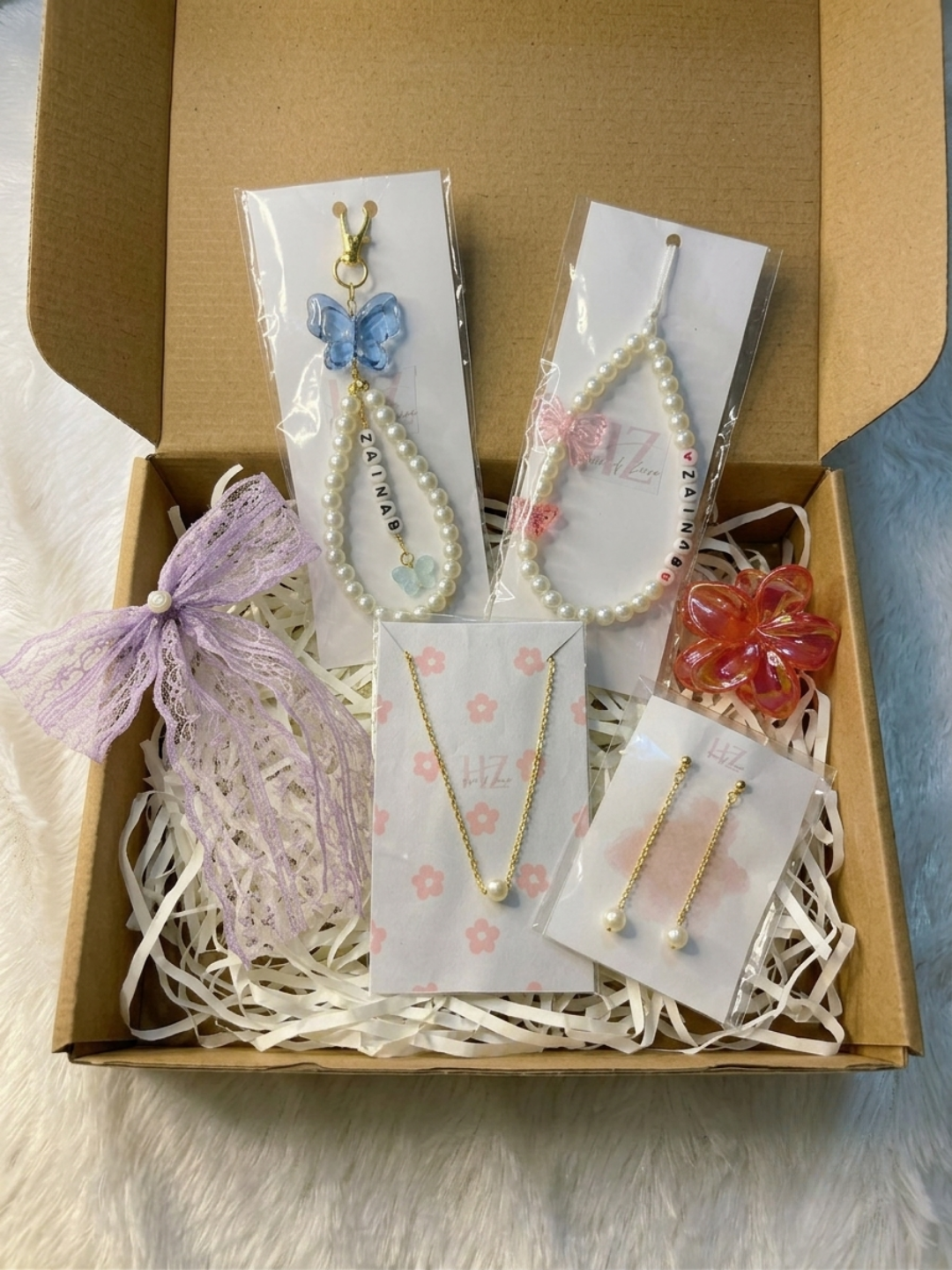 6-piece personalised Raksha Bandhan gift hamper with pearl necklace, pearl earrings, personalised bag charm, phone charm, bow and claw clip